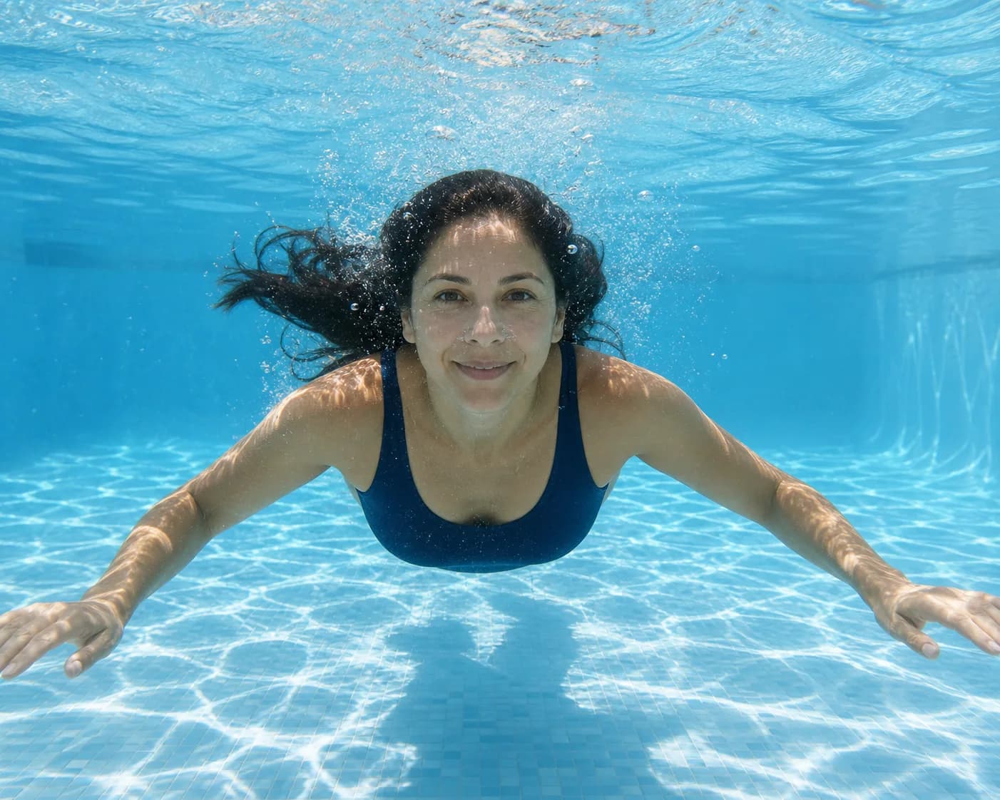 Mujer nadando en agua cristalina y bien balanceada